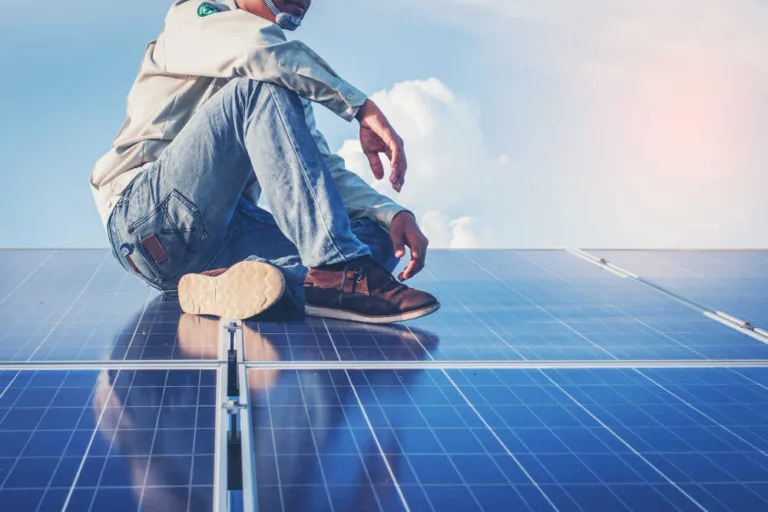 mężczyzna pośród paneli fotowoltaicznych